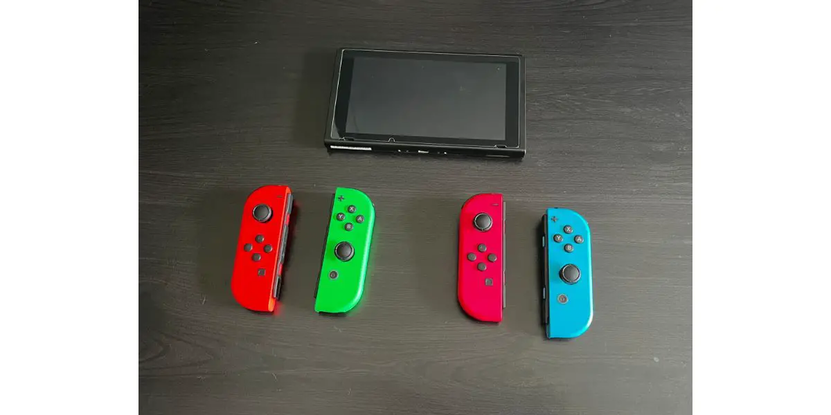 4 switch controllers with nintendo switch display screen on table