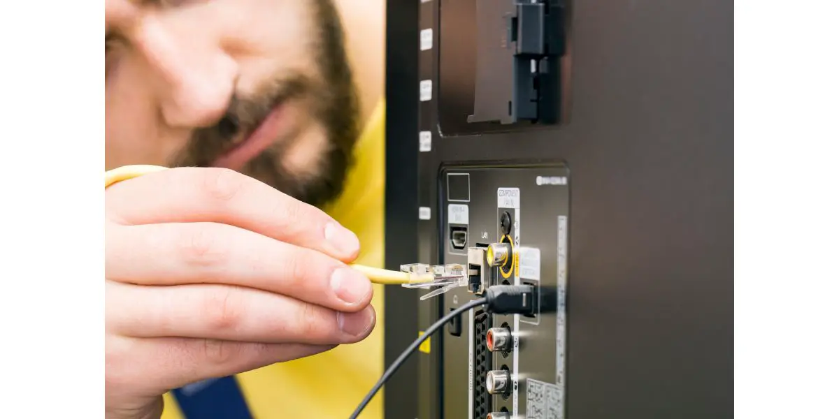 AdobeStock_107129654 man connects internet cable to the TV