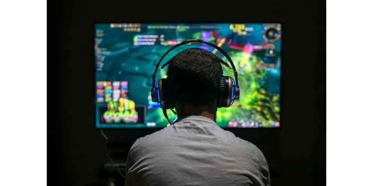 AdobeStock_145149580 Young gamer playing video game wearing headphone.