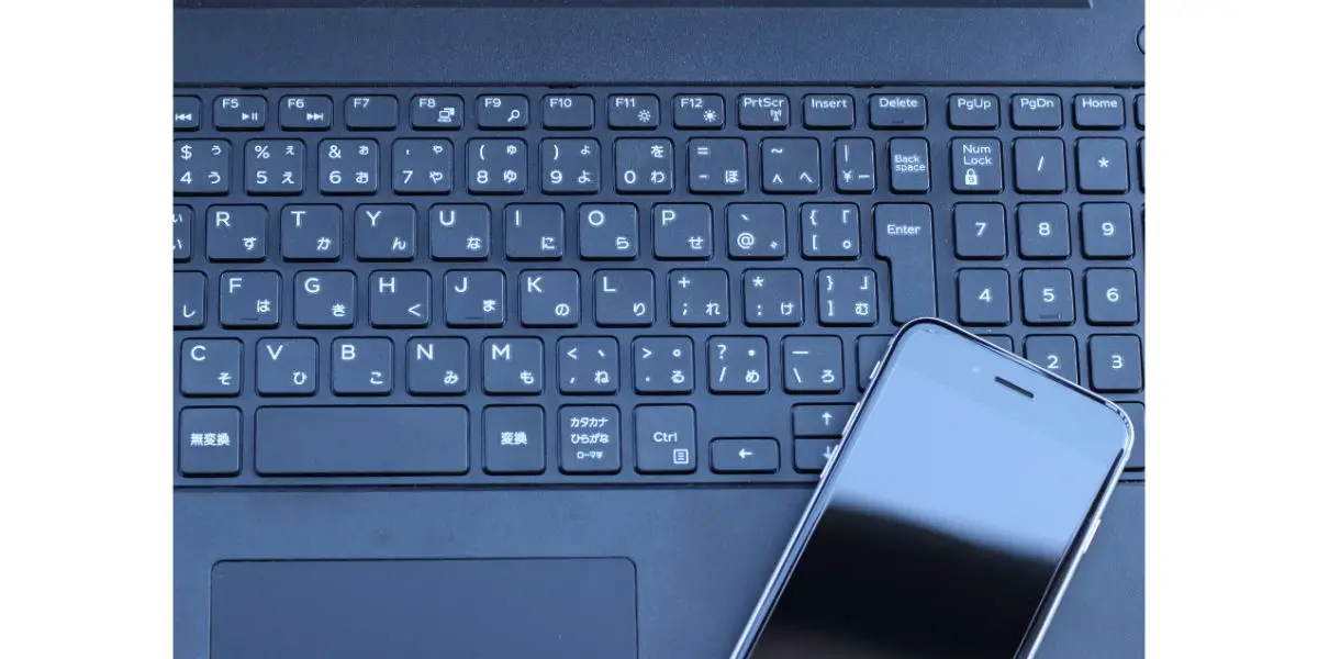 AdobeStock_146573145 Black smartphone on black laptop keyboard