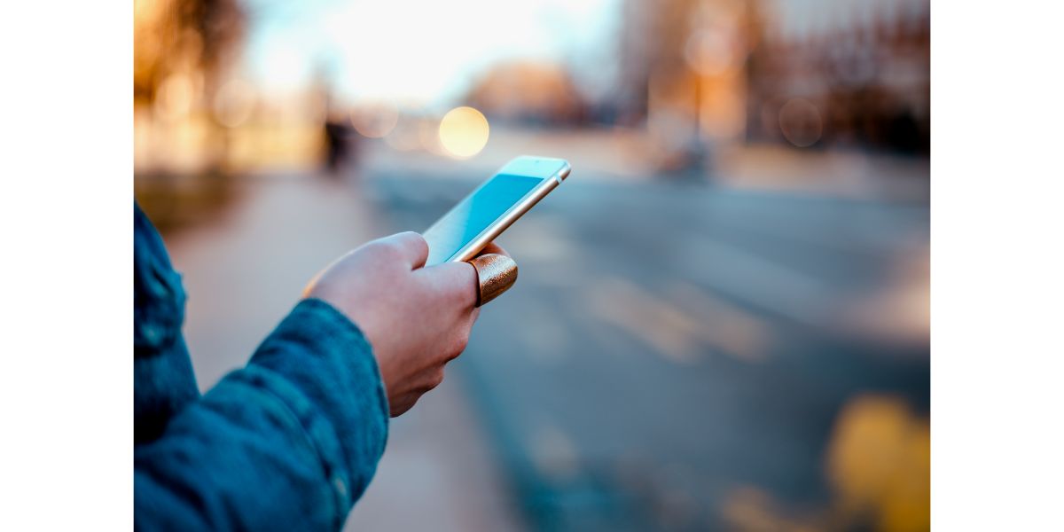 AdobeStock_191071565 Close-up image of a female hand using phone at city street