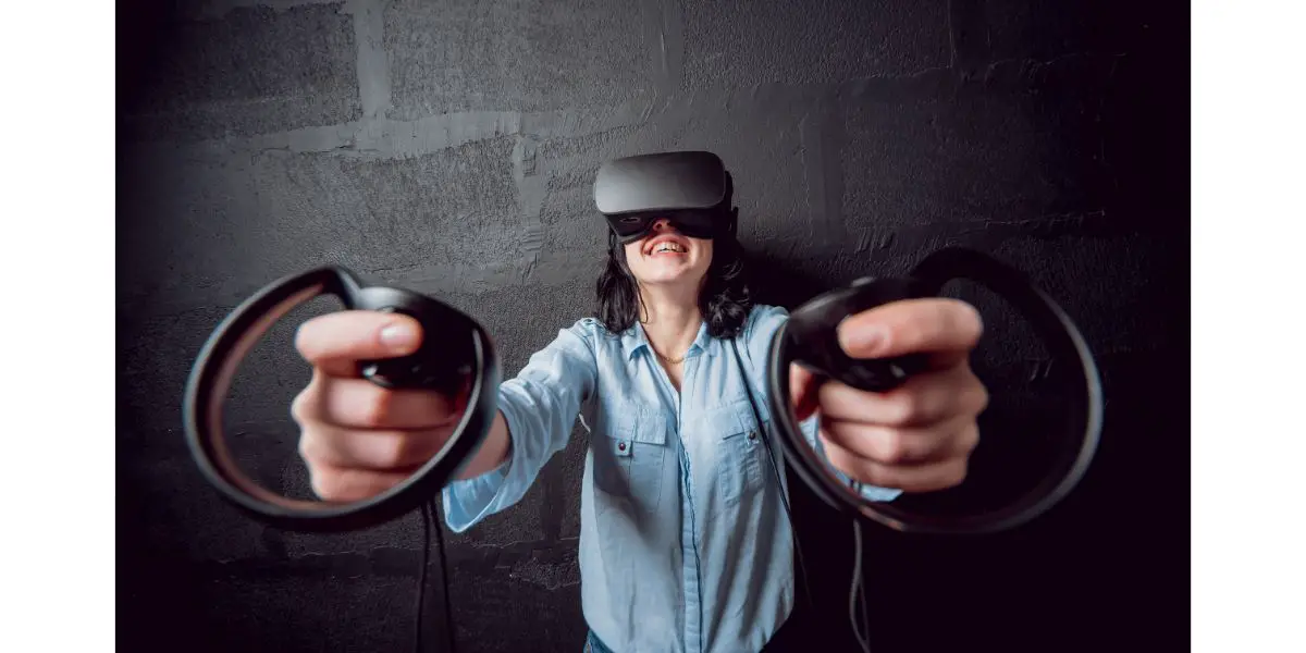 AdobeStock_193004430 girl wearing a black vr headset and controllers on black background