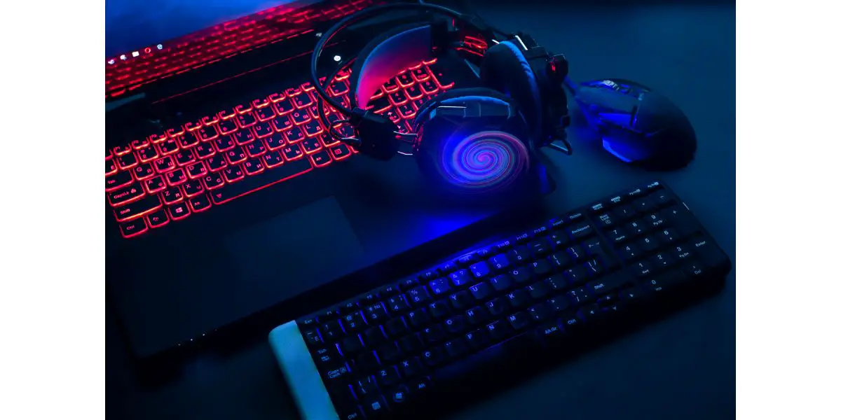 AdobeStock_203414725 Laptop, computer, keyboard, mouse, headphones accessories for the gamer on dark background