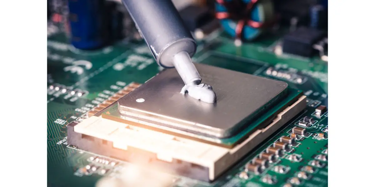 AdobeStock_210013195 the close up image of technician squeezing the fresh thermal paste compound on the top of cpu in the socket