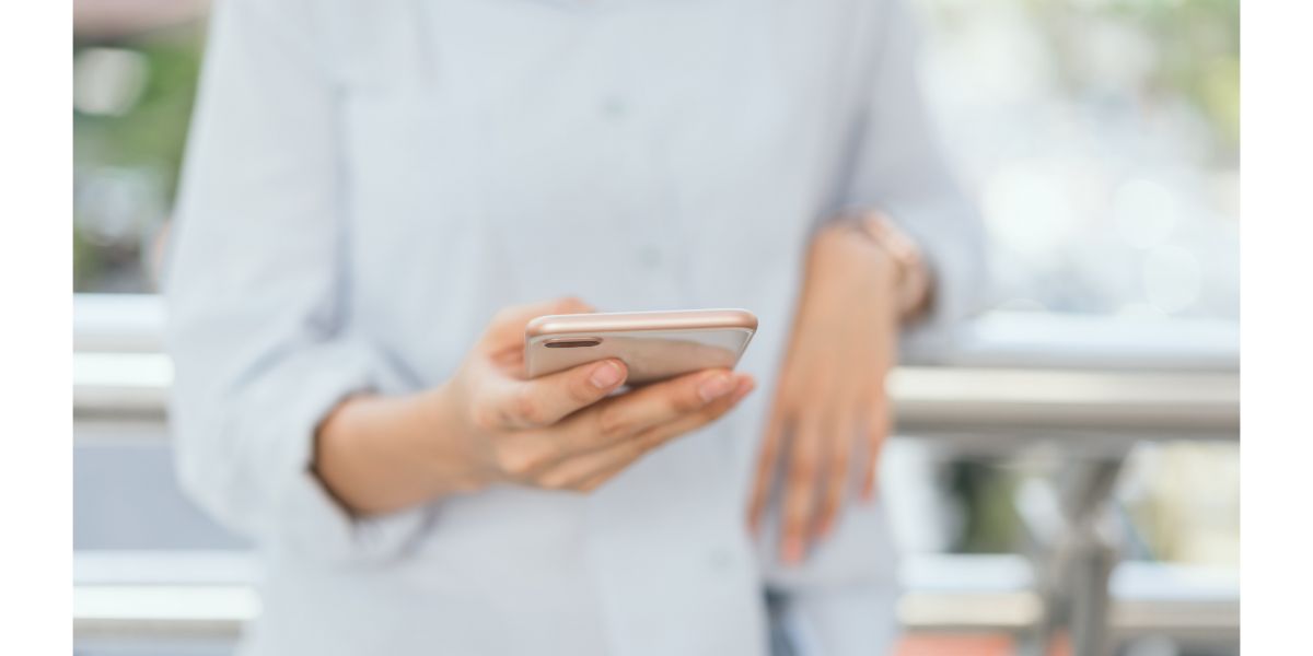 AdobeStock_215985621 woman using smartphone on staircase in public areas, During leisure time. The concept of using the phone is essential in everyday life.