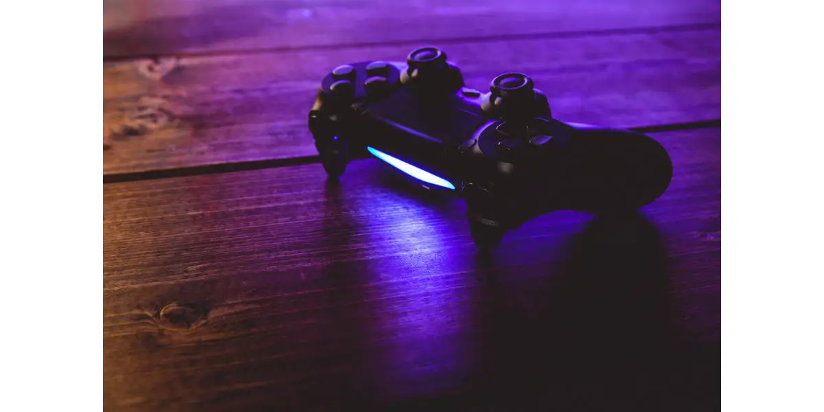 AdobeStock_222007750 Video game controller night with lights on wood background