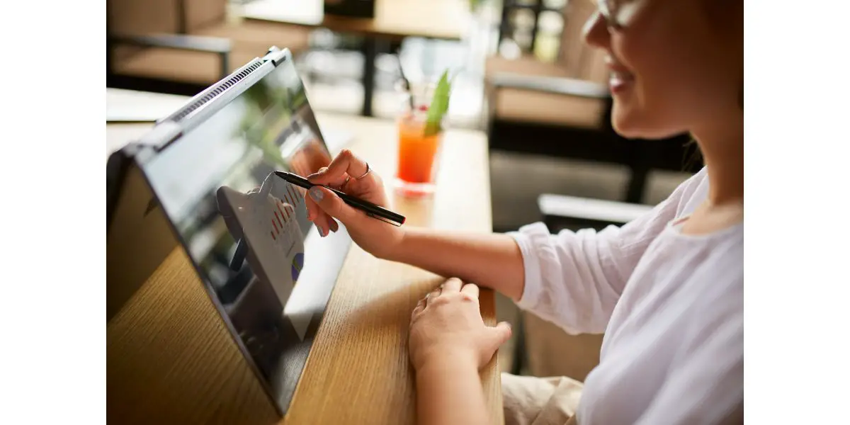 AdobeStock_223349560 businesswoman working on a presentation using a stylus on a 2 in 1 laptop that is in tent mode