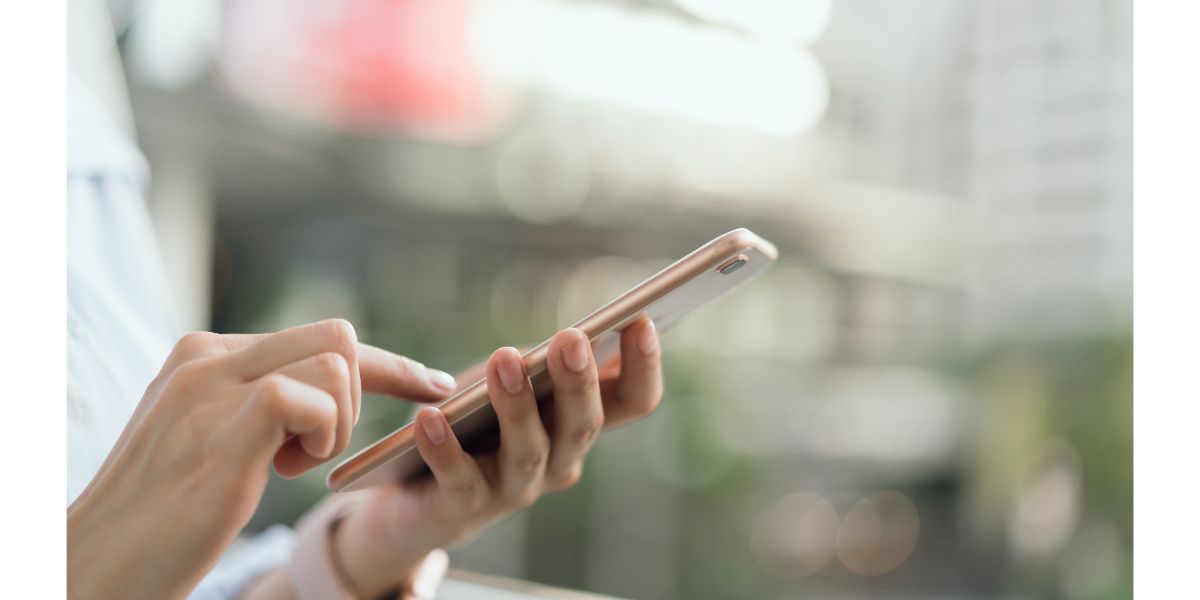 AdobeStock_236885727 woman using smartphone on staircase in public areas, During leisure time