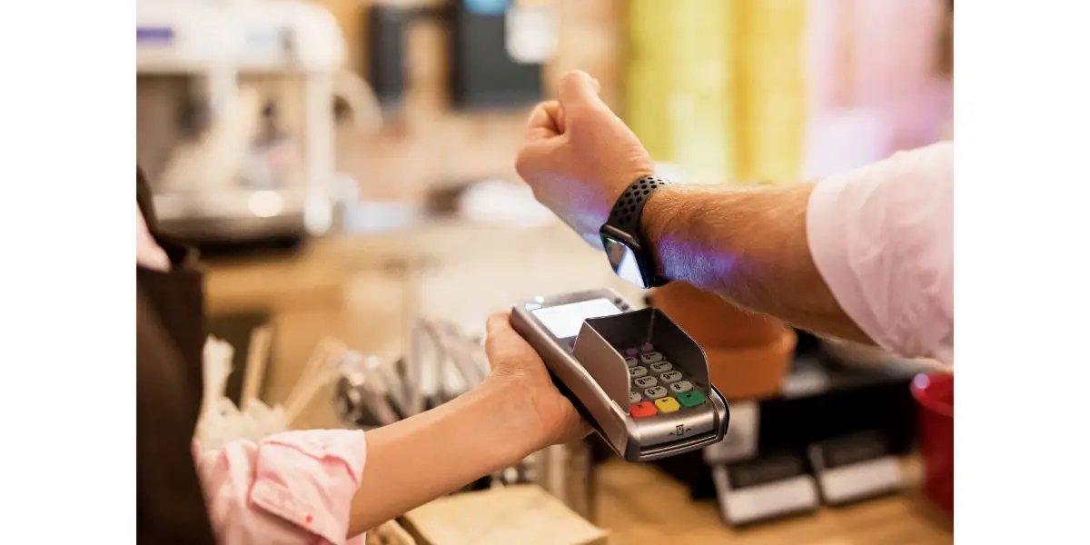 AdobeStock_254880973 Person paying at cafe with smart watch wirelessly on POS terminal
