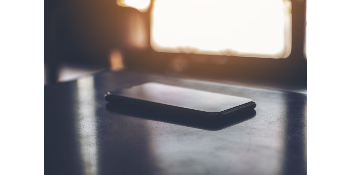 AdobeStock_256581978 A single black mobile phone on the table