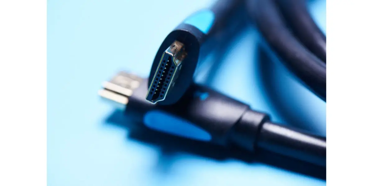 AdobeStock_259685514 Black HDMI cable adapter connector on a blue background isolated