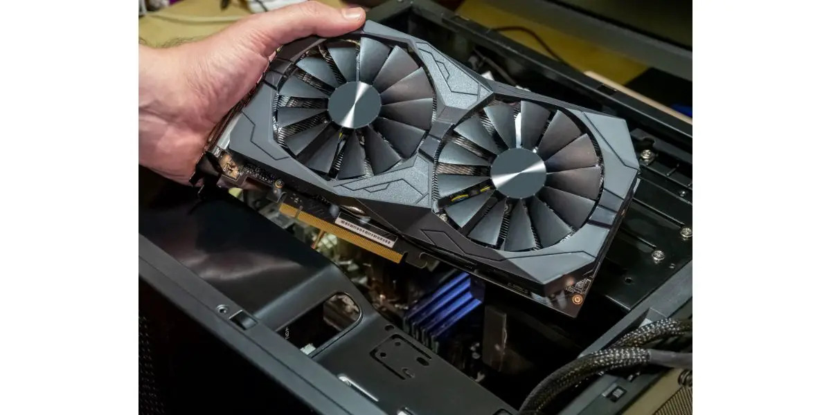 AdobeStock_260875295 Hand of technician installing graphic card in pc case