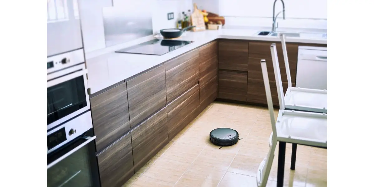 AdobeStock_264634535 robotic vacuum cleaner on the floor in modern kitchen with a dining area