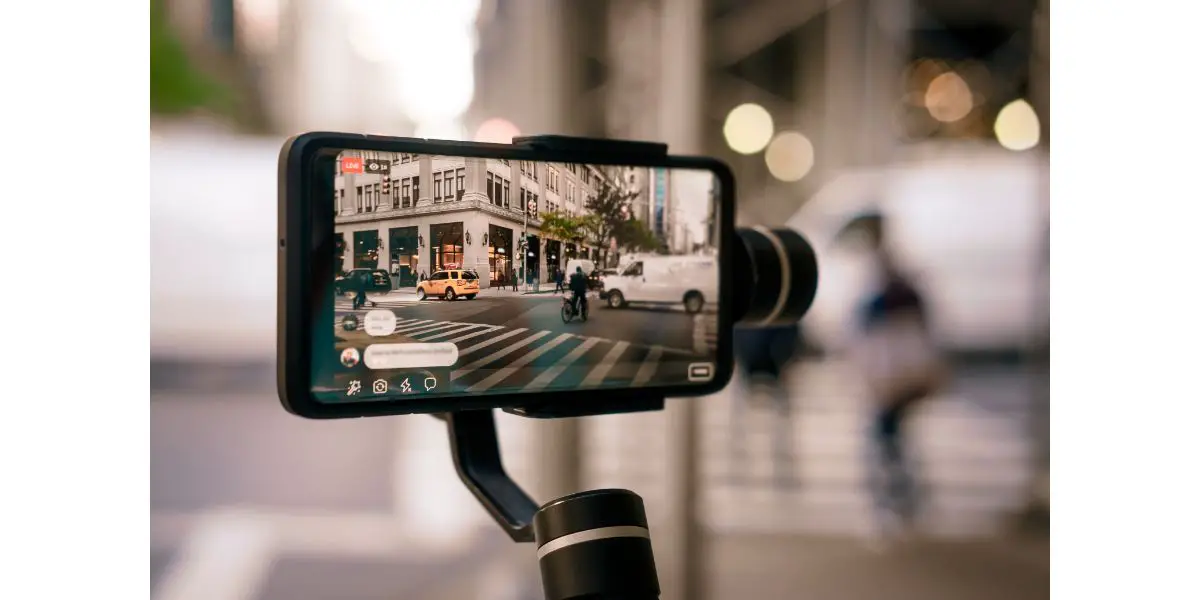 AdobeStock_303155350 Man using phone with stabilizer and taking pictures and live video in New York city. Vlog, video blogging, street photography concept.