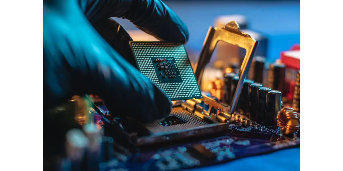 AdobeStock_311221204 Engineer repairman holding hands CPU to insert into the socket of the motherboard. Technology hardware in the neon light