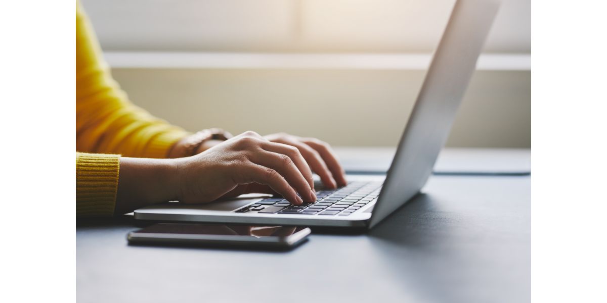 AdobeStock_318663472 Close up of female hands while typing on laptop