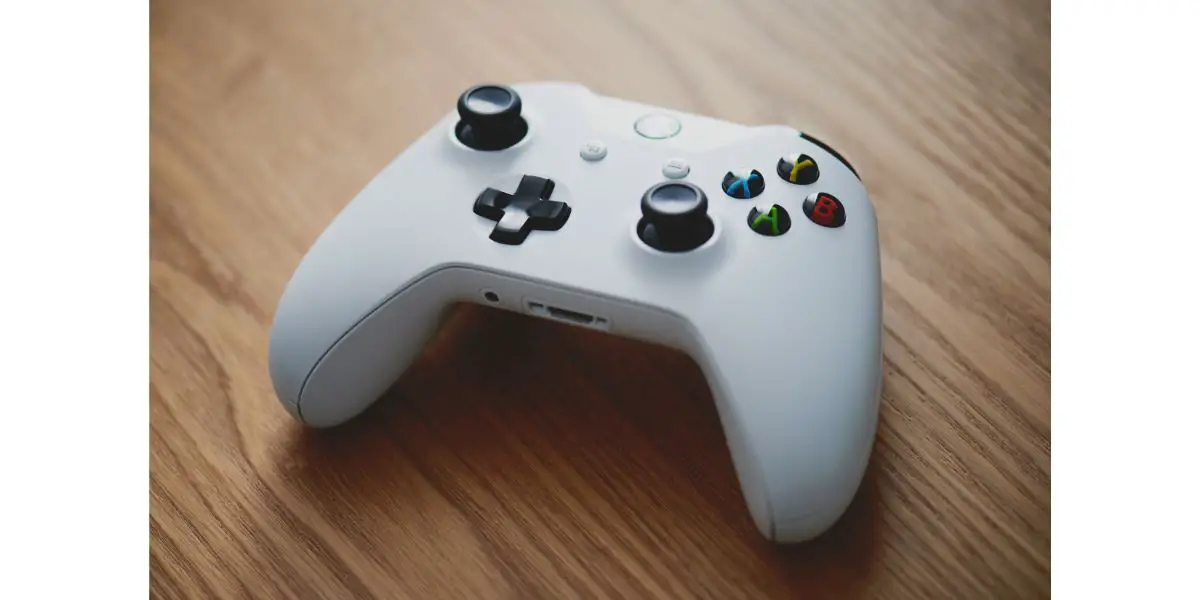AdobeStock_322398294_Editorial_Use_Only White xbox wireless controller wood background