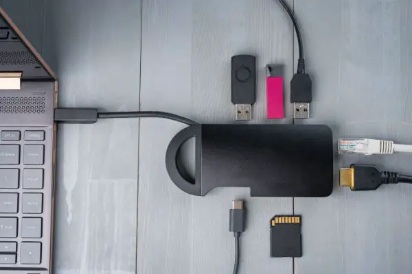 AdobeStock_325739200 USB Type C adapter or hub connected to the laptop with various accessories