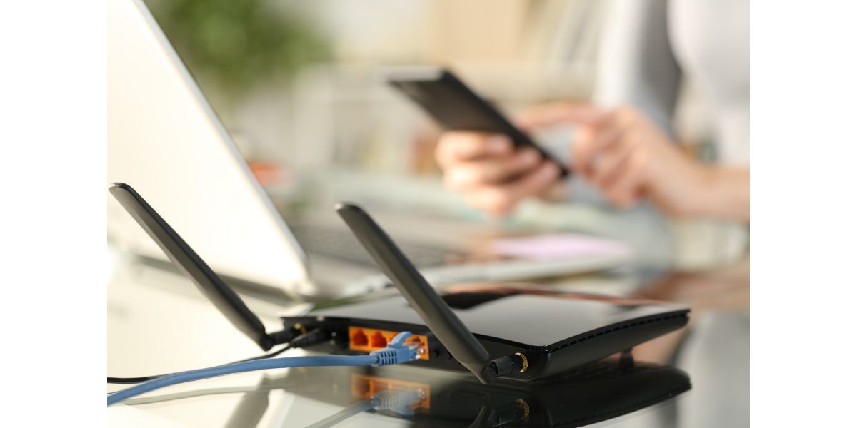 AdobeStock_335895820 Woman using multiple devices with broadband router on foreground