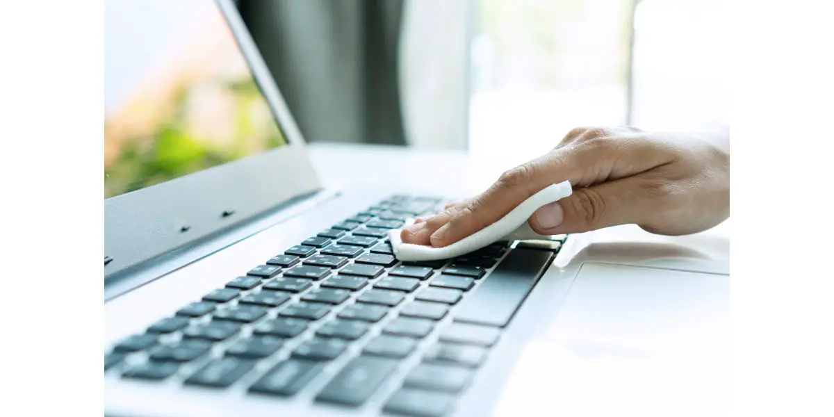 AdobeStock_345664192 Hand cleaning keyboard with disinfectant wet wipe. Concept of disinfecting surfaces