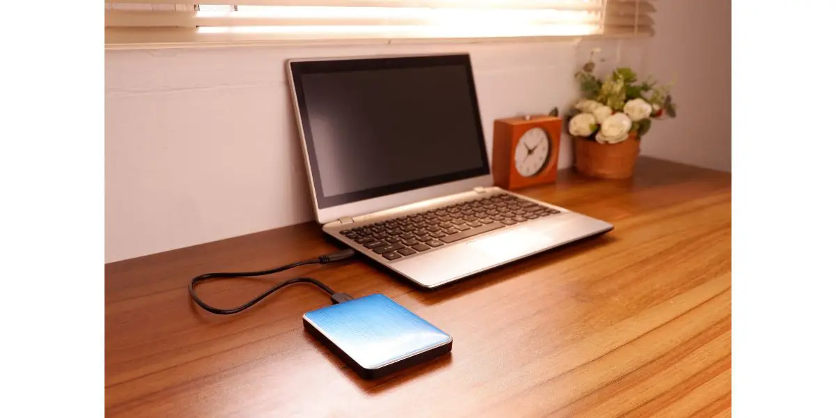 AdobeStock_371034706 Portable external hard drive USB3.0 connect to laptop computer on desk, Data transfer or backup personal files concept