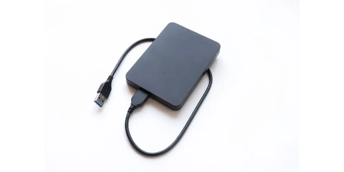 AdobeStock_372491641 External hard drive top view. Data transfer to external hard drive on white isolated background