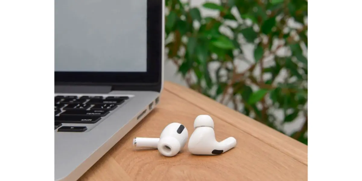 AdobeStock_377562395 wireless headphones called airpods on the table near the laptop