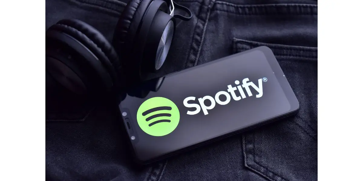 AdobeStock_399122232_Editorial_Use_Only Smartphone with spotify app and headphone on jeans