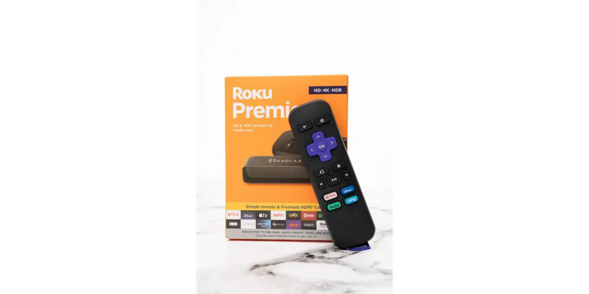 AdobeStock_419290259_Editorial_Use_Only Roku remote for streaming in front of orange retail box