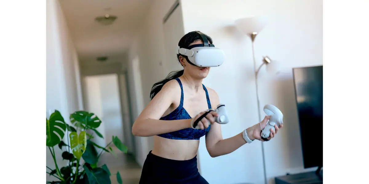 AdobeStock_421854309 Young woman doing virtual reality kickboxing at home in the living room using VR headset