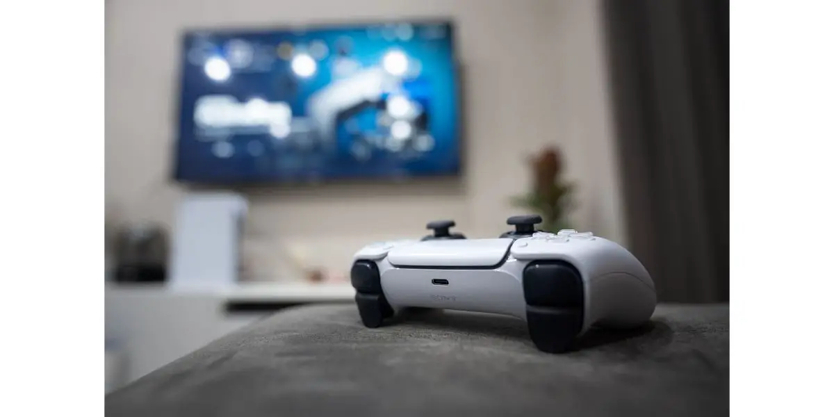 AdobeStock_426682425_Editorial_Use_Only The new technology wireless Play Station 5 joystick DualSense is placed on living room sofa during player is taking a break.
