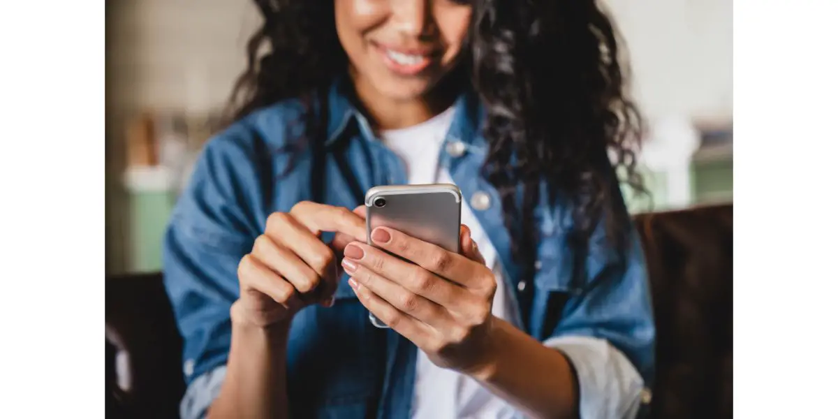 AdobeStock_429015029 Cropped shot of an african-american young woman using smart phone at home