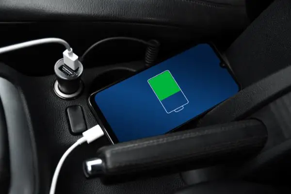 AdobeStock_435020624 Mobile phone ,smartphone, cellphone is charged ,charge battery with usb charger in the inside of car.