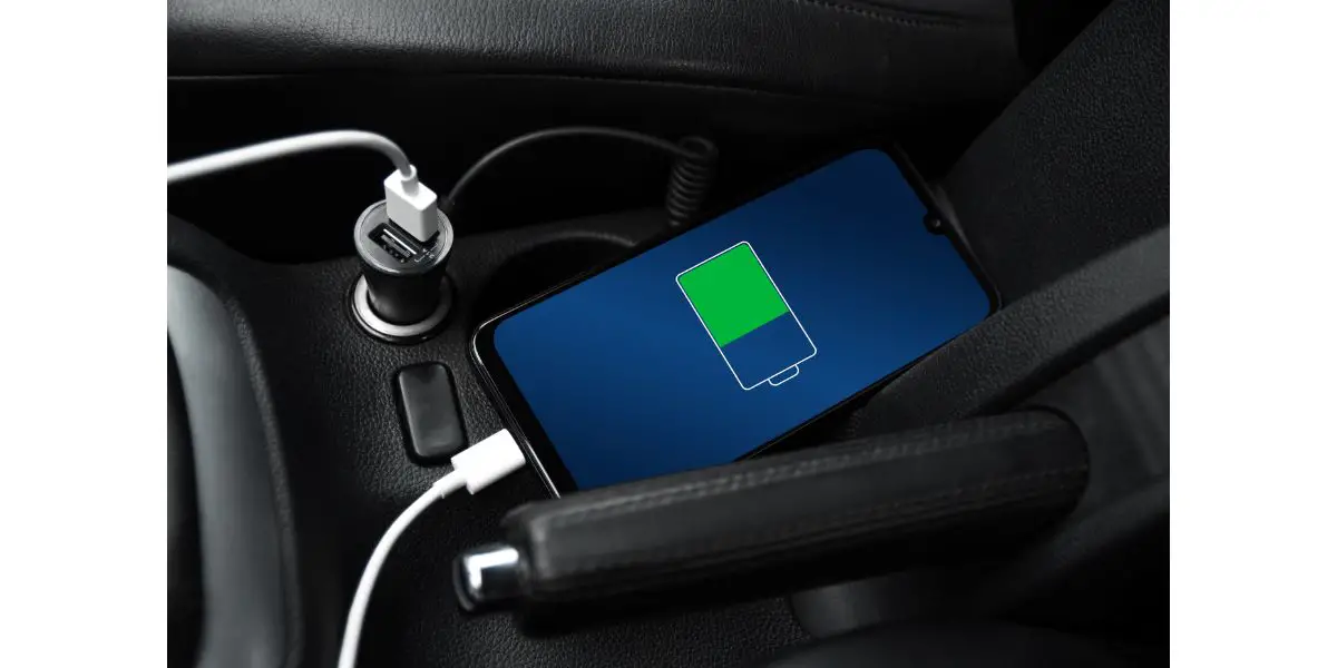 AdobeStock_436036472 Mobile phone ,smartphone, cellphone is charged ,charge battery with usb charger in the inside of car. modern black car interior