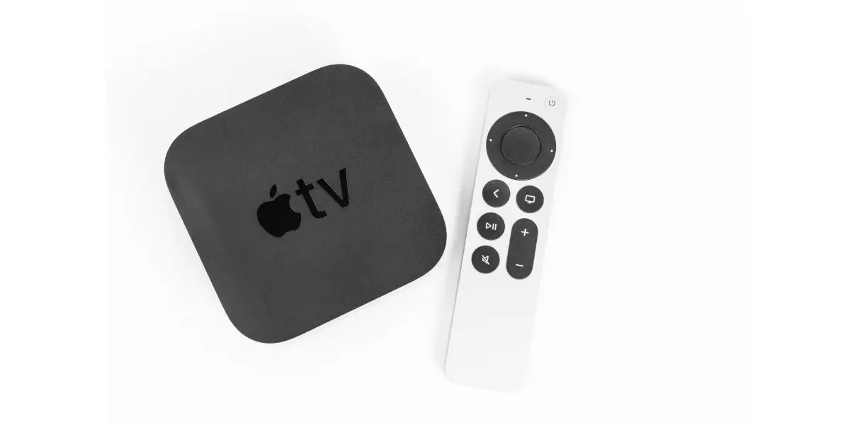 AdobeStock_442622484_Editorial_Use_Only New unpacked Apple TV 4K console and Siri Remote control with a touch-enabled clickpad laying nearby on a white background