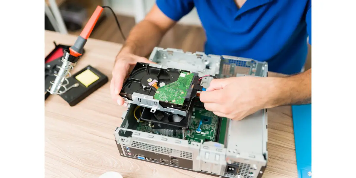 AdobeStock_444113588 Young man installing a new hard drive on an old computer