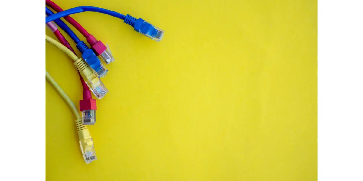 AdobeStock_451058817 Close up shot of assortment of colored ethernet cables on yellow background