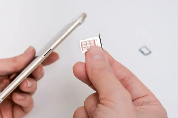 AdobeStock_456083560 Removing a sim card out of a smartphone, replacing simcard and changing number