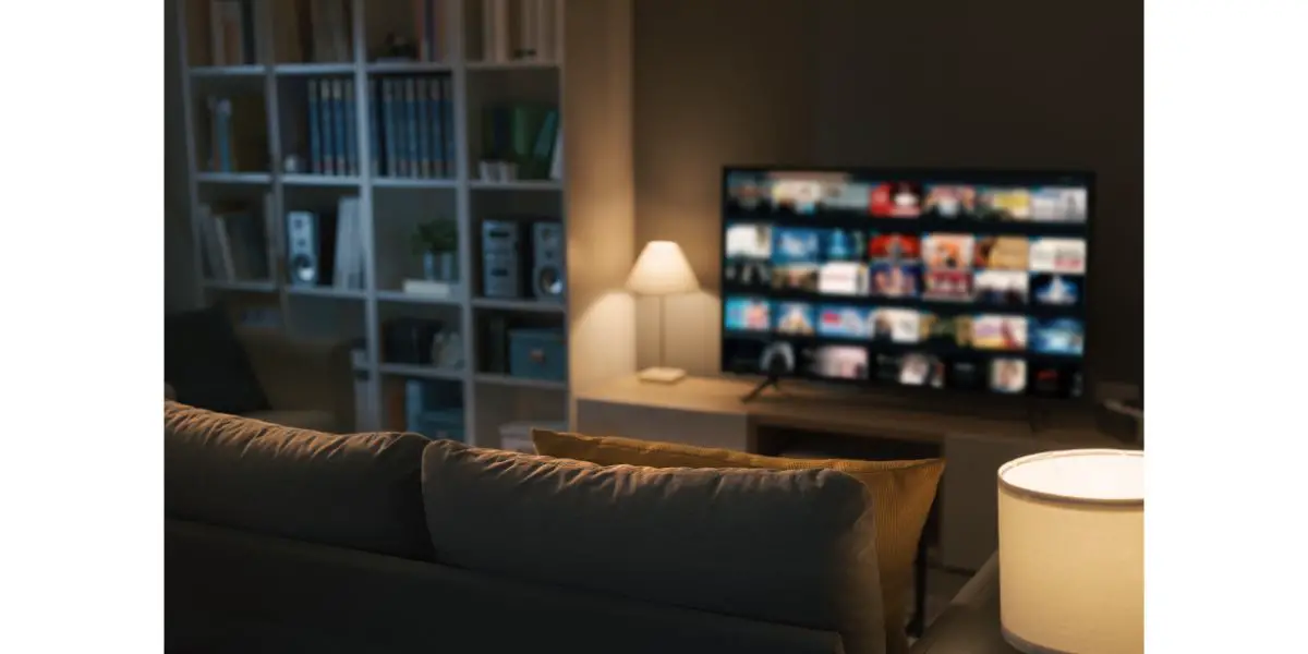 AdobeStock_469272180 smart tv with different shows listed blurred in the background with focus on living room couch