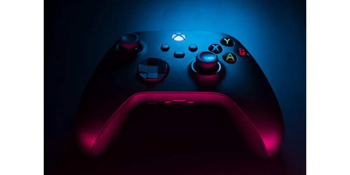 AdobeStock_472700938_Editorial_Use_Only Xbox Series S Carbon Black controller isolated with colored lights illuminating it