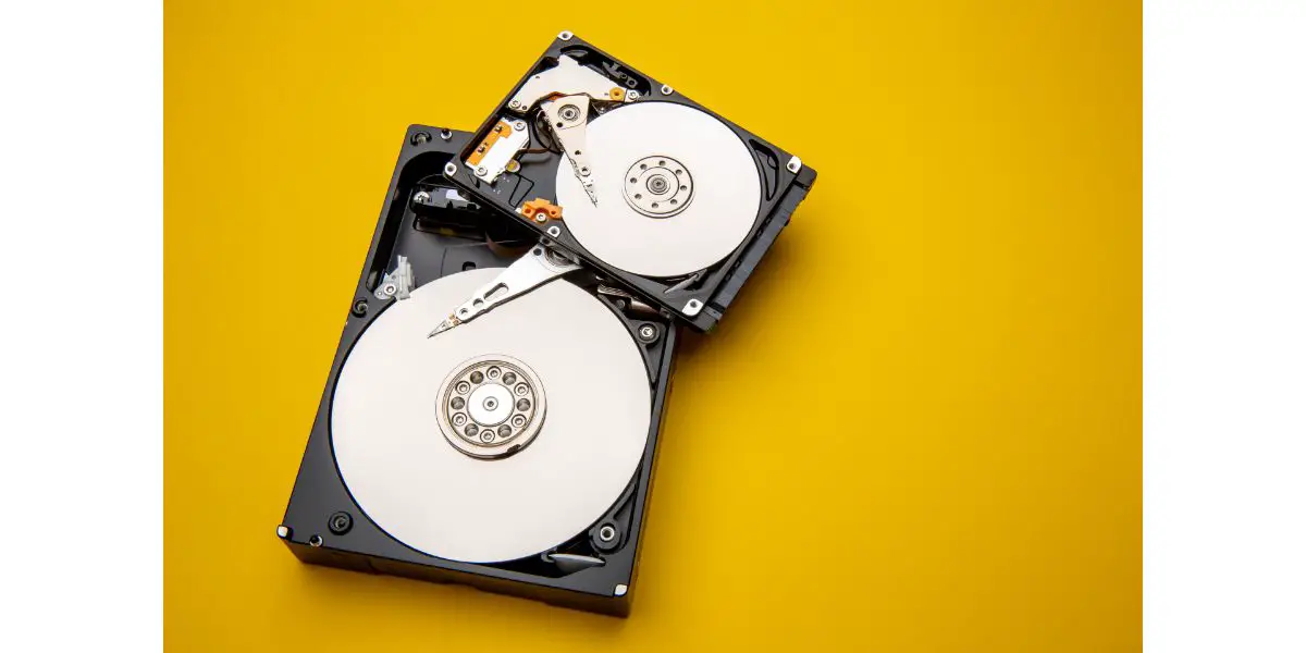 AdobeStock_484979558 hard drive disks opened up and on orange background