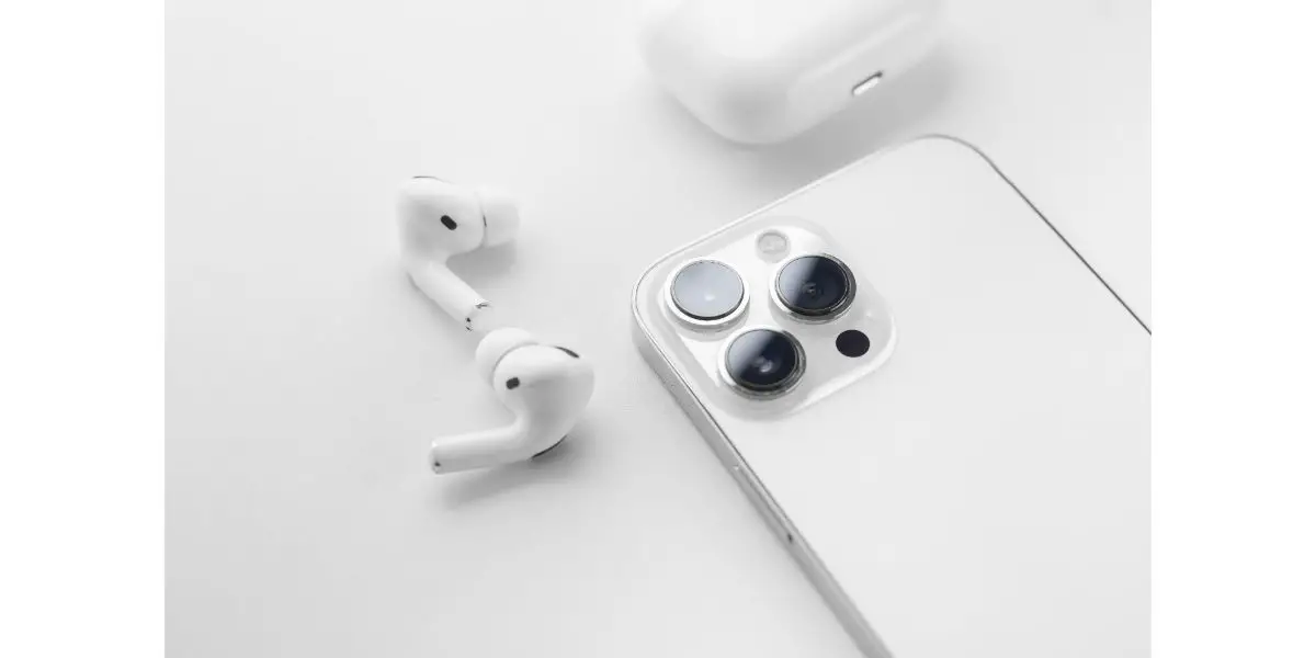 AdobeStock_486481393 white wireless headphones next to a white smartphone on a white background