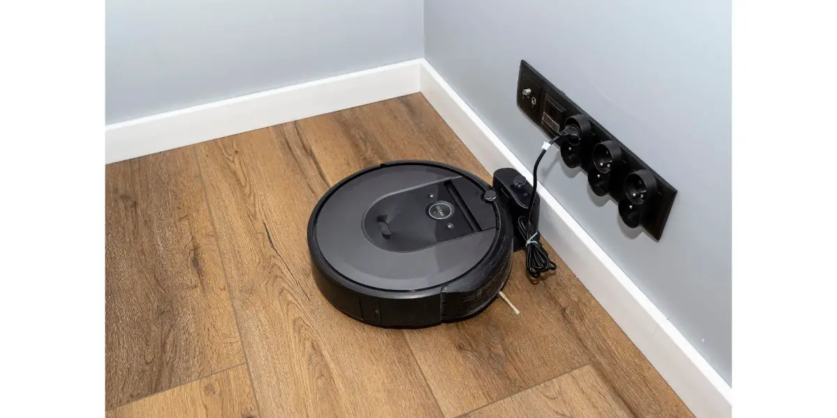 AdobeStock_491080451 A modern robotic vacuum cleaner that charges in a docking station, an autonomous cleaning robot.
