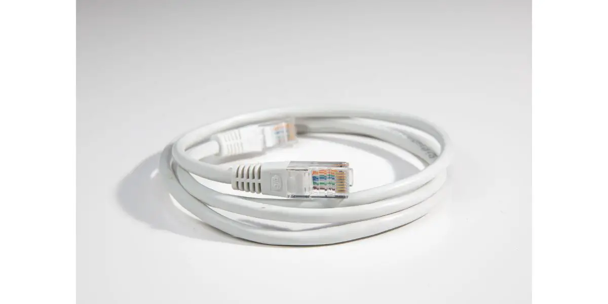 AdobeStock_498140791 Close up of white ethernet network cable coiled in grey white background