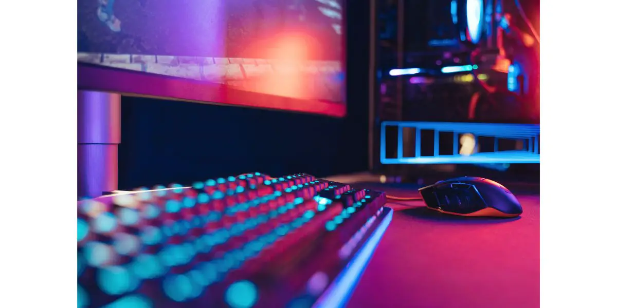 AdobeStock_501381301 Close-up of professional gaming setup laying on desktop in neon lights.