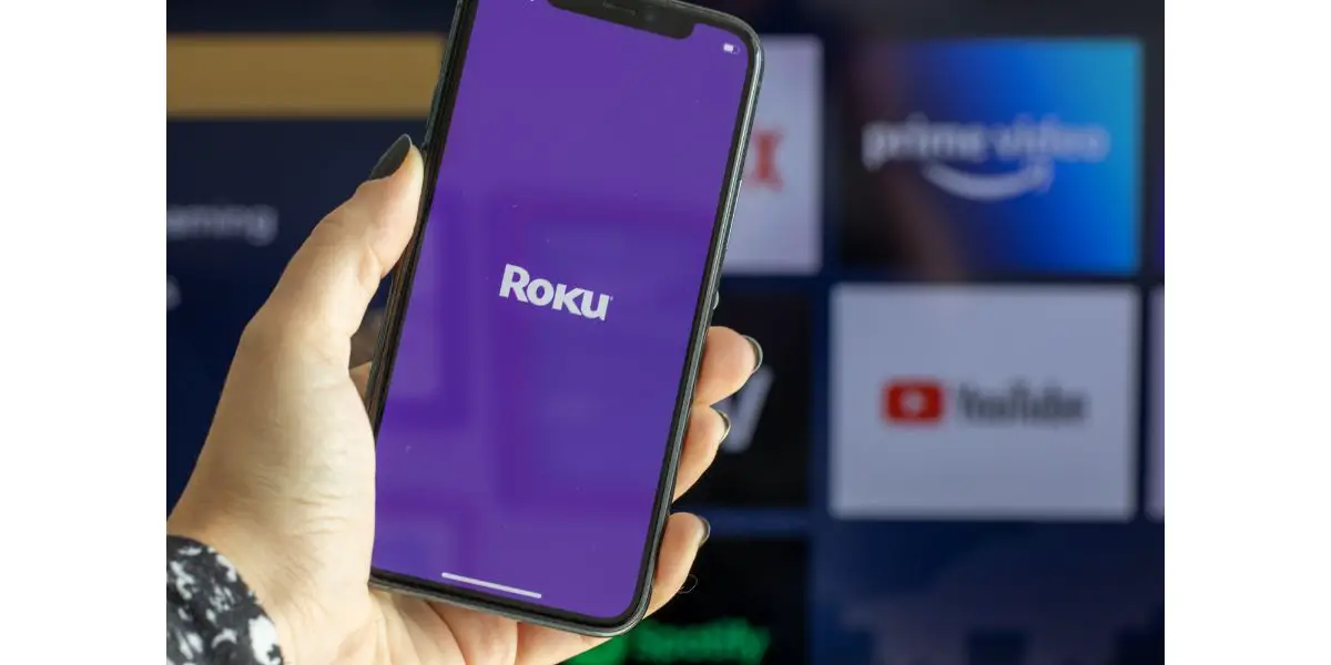 AdobeStock_505428573_Editorial_Use_Only Roku Express app on smartphone screeen in front of roku selection on smart tv. Streaming service
