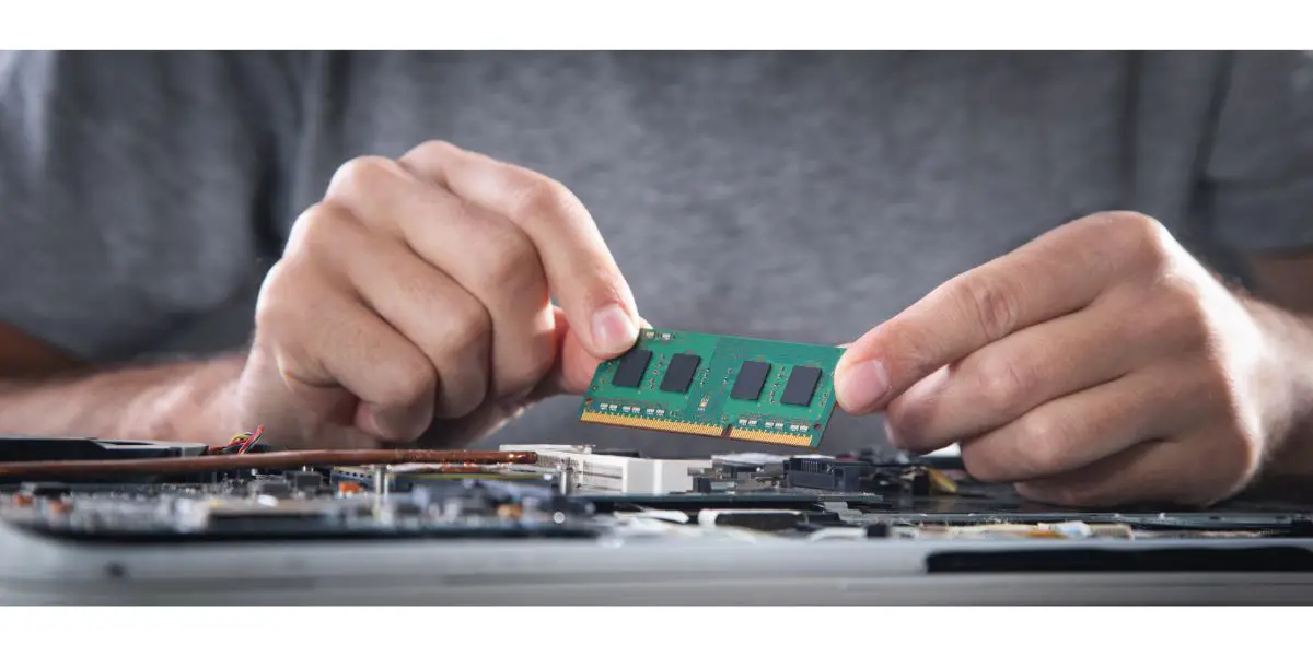 AdobeStock_507354764 Technician installing random access memory on laptop computer.