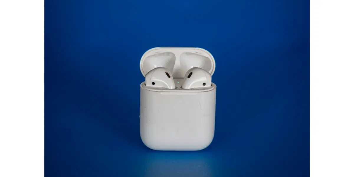 AdobeStock_509918042 Apple airpods 2 wireless bluetooth headphones in an open white case on a blue background