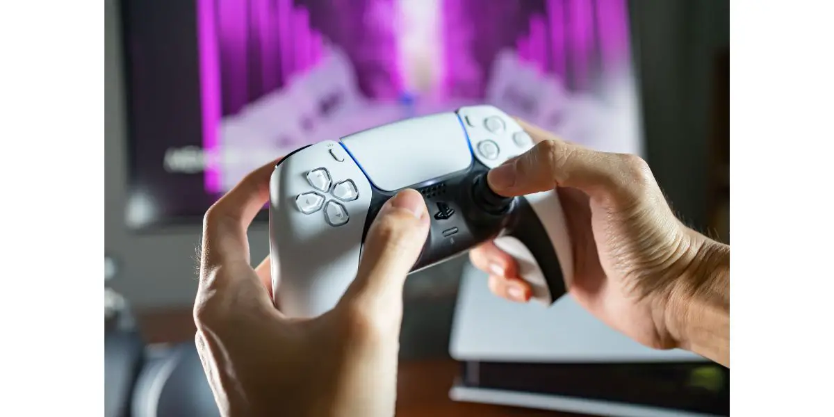AdobeStock_519559648_Editorial_Use_Only Gamer playing PlayStation 5 game console with DualSense controller