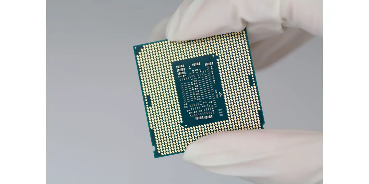 AdobeStock_542762887 man wearing white gloves holding a cpu on grey background